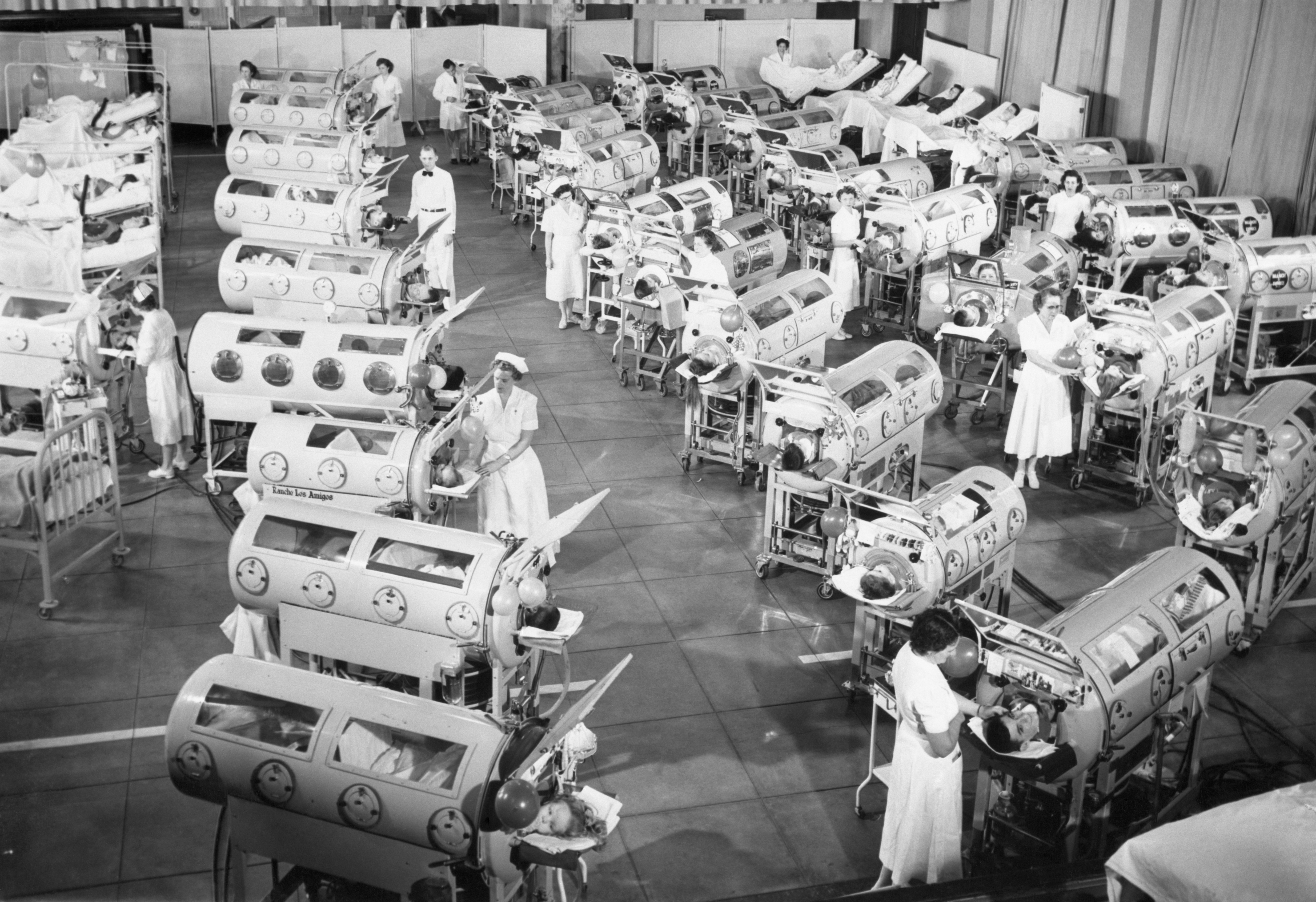 Vintage iron lung medical device in hospital room with soft lighting